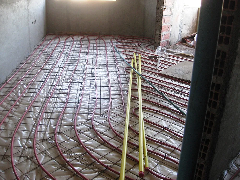 Une chape anhydrite coulée sur un chauffage au sol, dans une pièce en travaux.