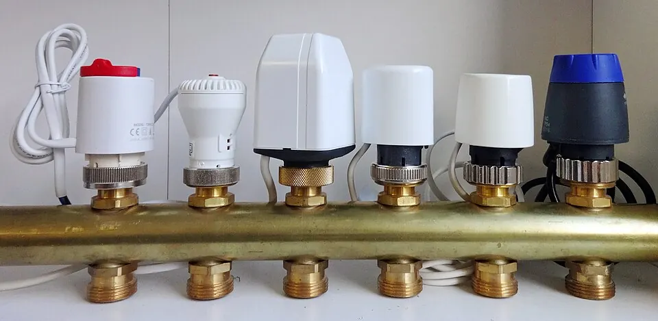 Des têtes thermostatiques montées sur un collecteur en laiton.