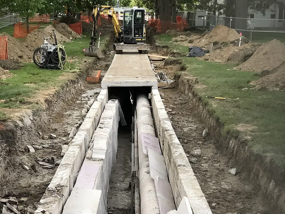 Conduites de chauffage à distance pré-isolées, posées au fond d'une tranchée.