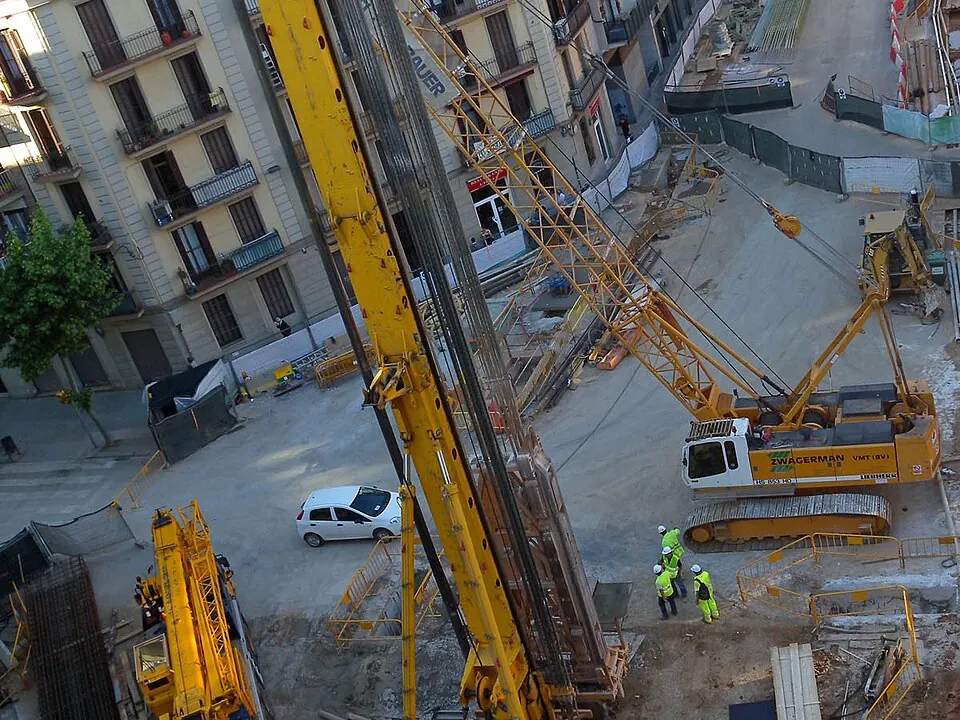Une foreuse sur chenilles au travail sur un chantier urbain.
