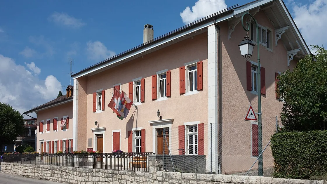 Le bâtiment de l'administration communale d'Arzier, façade crépie et volets rouges