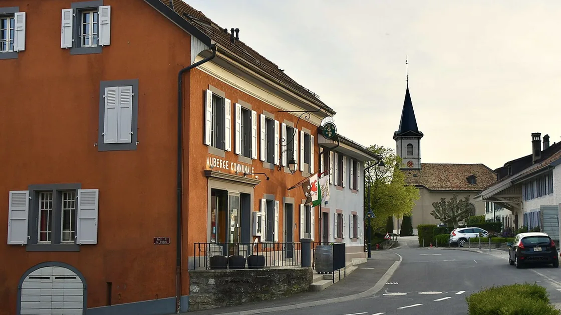 Le centre du village de Bursinel, maison ocre et clocher au fond de la rue
