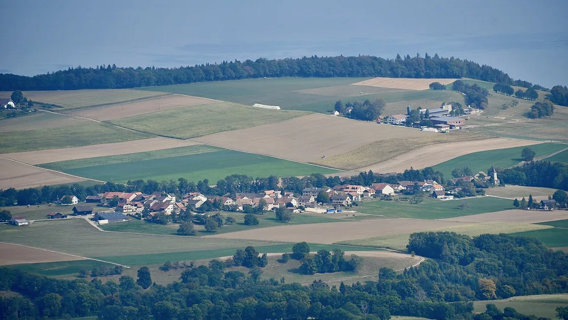 Vue aérienne du village de Burtigny entouré de champs et de forêts