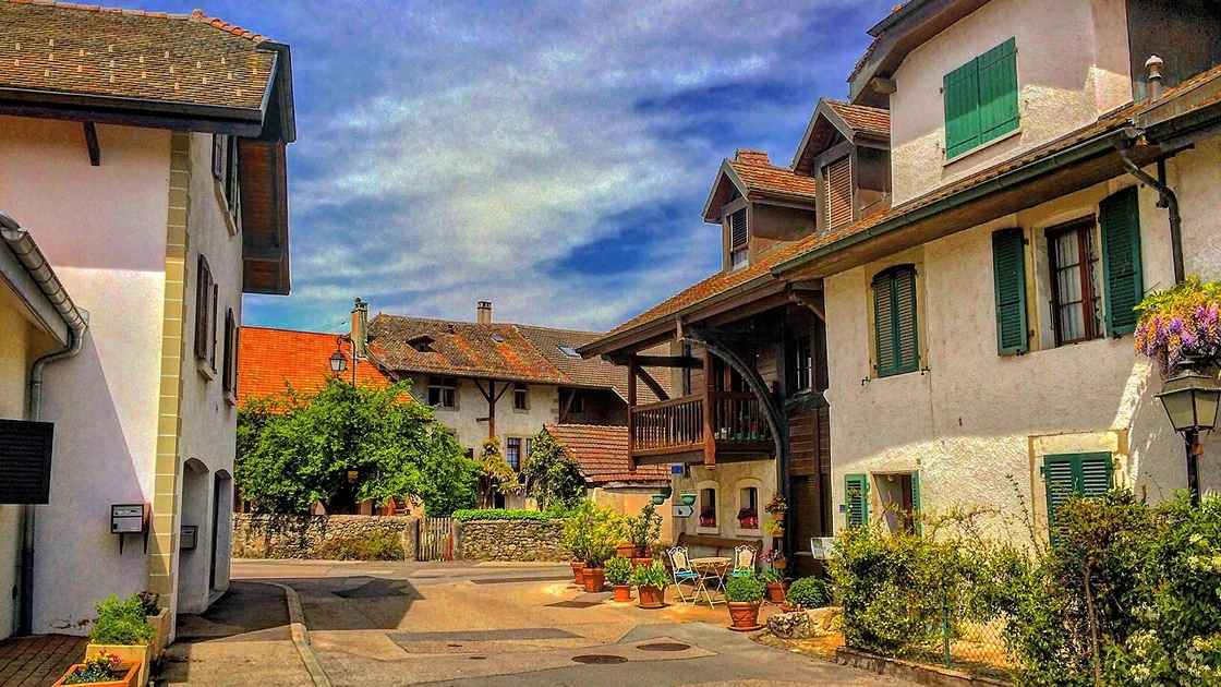 Une rue de Commugny, maisons anciennes et fleurs aux fenêtres