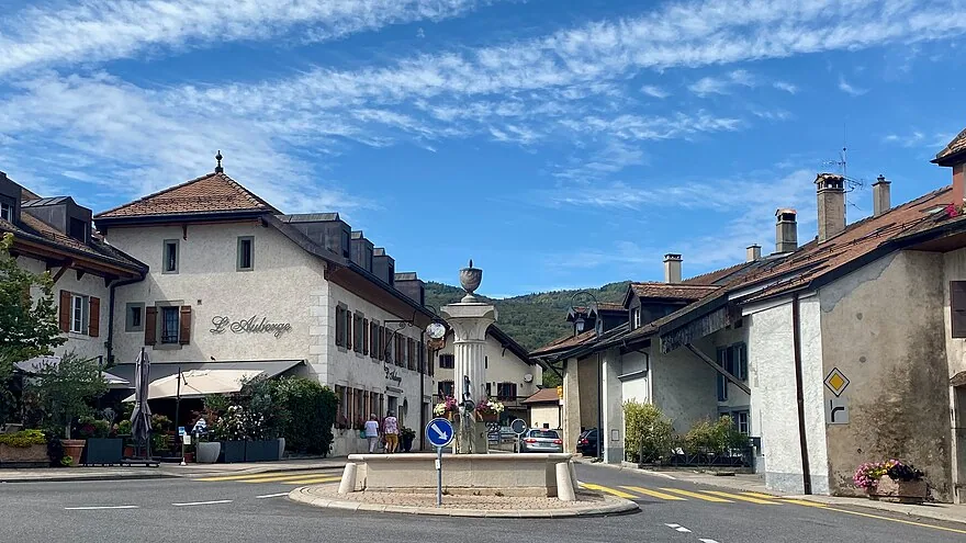 La place du Village de Genolier, sa fontaine et ses façades