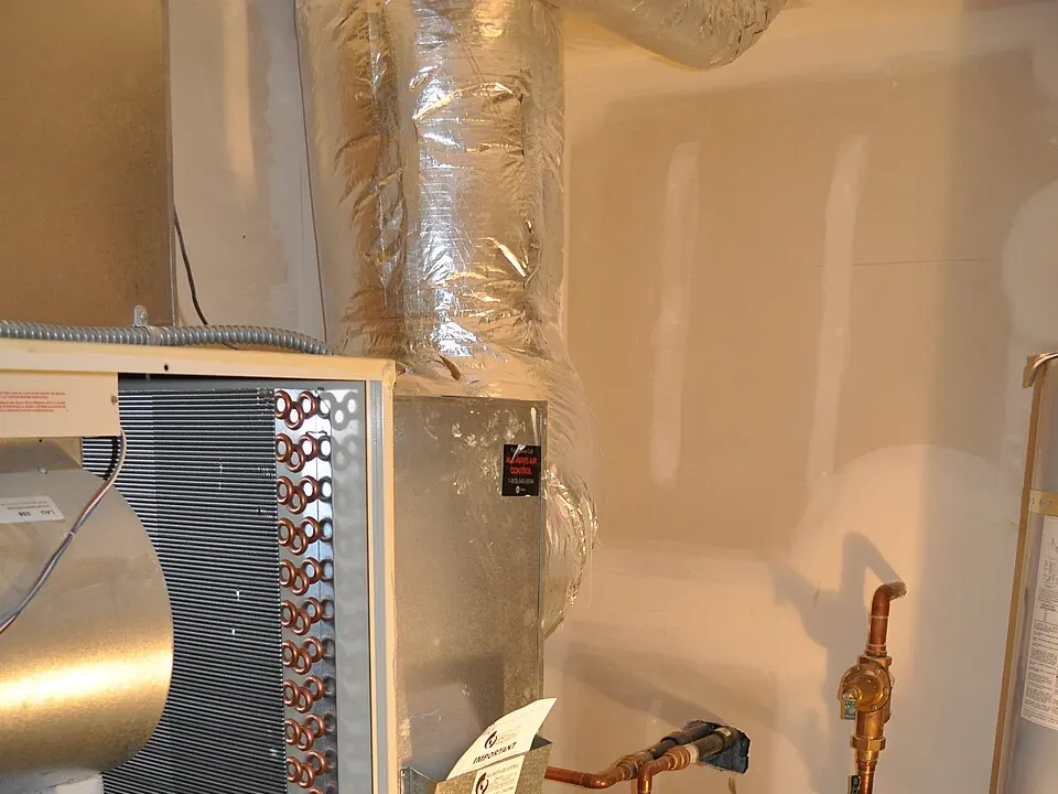 Un module intérieur de pompe à chaleur raccordé en cuivre dans un local technique.